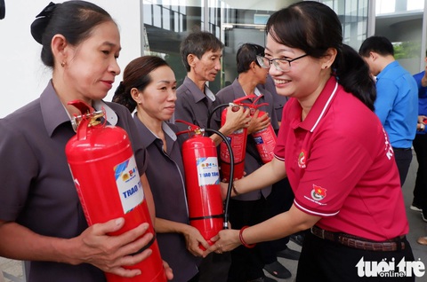 Thiếu nhi TP.HCM vui chơi, nhận quà trong ngày cao điểm vì đàn em- Ảnh 2. Phó chủ tịch UBND TP.HCM Trần Thị Diệu Thúy trao bình chữa cháy cho cư dân chung cư Sadora (TP Thủ Đức) sau lễ ra quân - Ảnh: K.ANH