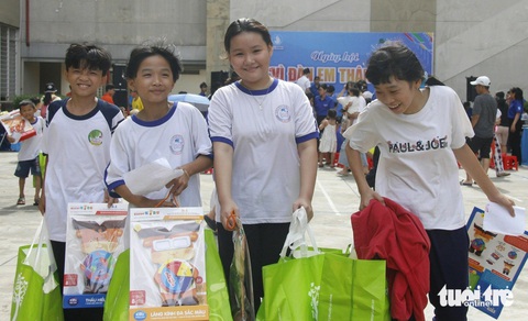 Thiếu nhi TP.HCM vui chơi, nhận quà trong ngày cao điểm vì đàn em- Ảnh 1. Các bạn nhỏ TP.HCM khệ nệ với những túi quà lớn được nhận tại ngày hội