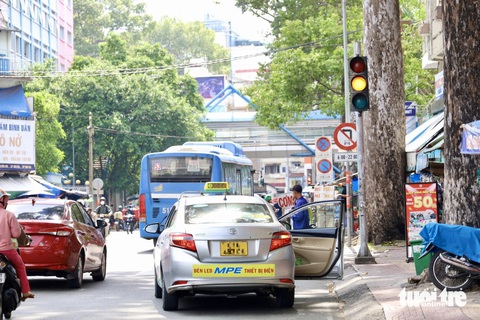 Taxi, xe dịch vụ đậu la liệt quanh Bệnh viện Từ Dũ, Bình Dân- Ảnh 5. Xe taxi đậu, mở cửa toang hoang mặc dù ở phía xa là biển cấm đậu, cấm dừng - Ảnh: NGỌC QUÝ