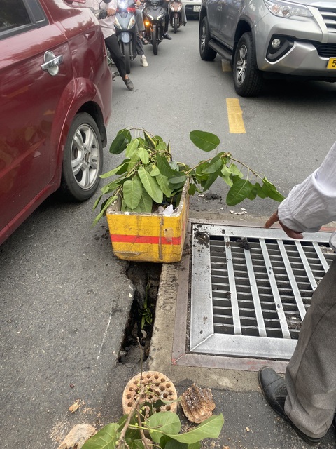 Hố ga sụp trên đường, nhiều người đi xe máy bị té ngã- Ảnh 1. Người dân dùng thùng xốp cảnh báo người đi đường - Ảnh: HỒNG ĐIỆP