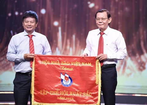 TP.HCM trao giải báo chí lần 42, báo Tuổi Trẻ đoạt 10 giải- Ảnh 3. Phó chủ tịch Hội Nhà báo Việt Nam Trần Trọng Dũng trao Cờ thi đua tập thể xuất sắc năm 2023 cho Hội Nhà báo TP.HCM cho Chủ tịch Hội Nhà báo TP.HCM Nguyễn Tấn Phong - Ảnh: QUANG ĐỊNH