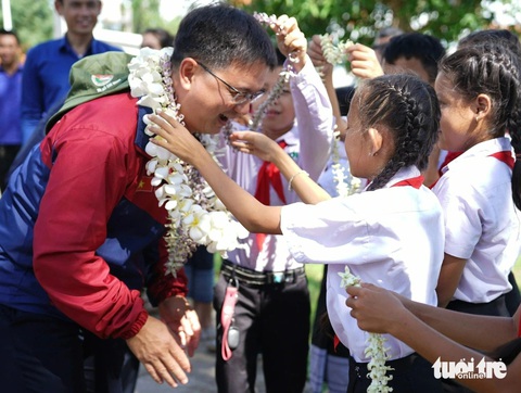 Chiến sĩ tình nguyện hè TP.HCM vẽ phòng học, làm sân chơi cho trẻ em Lào- Ảnh 1. Học sinh Trường tiểu học Kilomet số 3 (tỉnh Attapeu, Lào) đeo vòng hoa cho Trưởng Ban Dân vận Thành ủy TP.HCM Nguyễn Mạnh Cường - Ảnh: DIỆU QUÍ