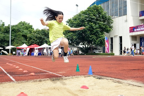 Đại sứ quán Pháp tổ chức Ngày Olympic hưởng hứng Olympic Paris 2024- Ảnh 4. Các em học sinh trải nghiệm môn nhảy xa trong Ngày hội Olympic - Ảnh: HOÀNG TÙNG