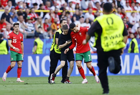 UEFA siết chặt an ninh sau sự cố CĐV lao xuống sân tiếp cận Ronaldo- Ảnh 1. Lực lượng an ninh bất lực trước các cổ động viên quá khích - Ảnh: REUTERS