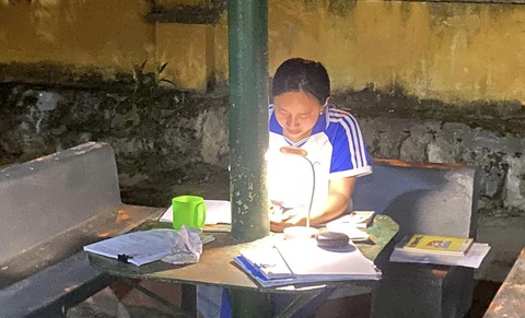 Sĩ tử vùng cao ôn thi tốt nghiệp THPT từ sáng tới đêm- Ảnh 13. Một nữ sinh Trường phổ thông dân tộc nội trú THCS & THPT Si Ma Cai ngồi ôn bài trong một góc sân trường giữa đêm