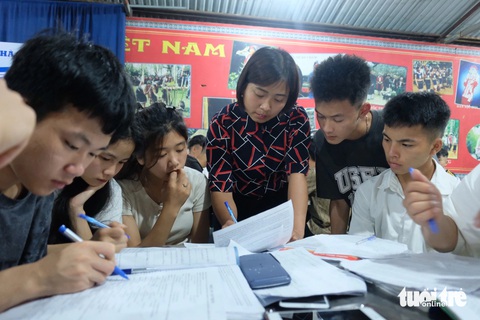 Thầy cô vào bếp làm suất ăn đêm khích lệ học trò ôn thi tốt nghiệp- Ảnh 2. Mỗi buổi tối sẽ có 2 - 3 giáo viên đến khu bán trú hỗ trợ học sinh học nhóm, luyện đề. Trong ảnh, cô Lý Thị Di đang hỗ trợ học sinh giải đề thi tiếng Anh