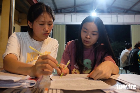 Thầy cô vào bếp làm suất ăn đêm khích lệ học trò ôn thi tốt nghiệp- Ảnh 3. Cô giáo Linh (bên phải) tận tình giải đề tiếng Anh, chữa từng lỗi nhỏ cho học sinh