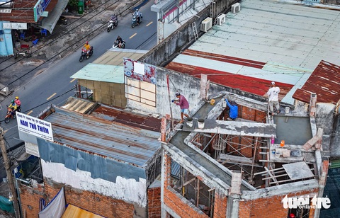 Bà con ở đường Nguyễn Thị Định đồng loạt tháo dỡ nhà, giao mặt bằng mở rộng đường- Ảnh 1. Nhiều nhà dân sinh sống trên đường Nguyễn Thị Định bắt đầu sửa sang nhà cửa, xây lùi nhà vào trong để bàn giao mặt bằng mở rộng đường - Ảnh: CHÂU TUẤN