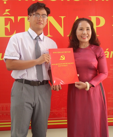 TP.HCM: Học sinh xuất sắc trong học tập, nghiên cứu khoa học được kết nạp Đảng- Ảnh 2. Bà Trương Thị Bích Thủy, hiệu trưởng Trường THPT Hùng Vương, trao quyết định kết nạp Đảng cho Hà Minh Nhật - Ảnh: KIM ANH