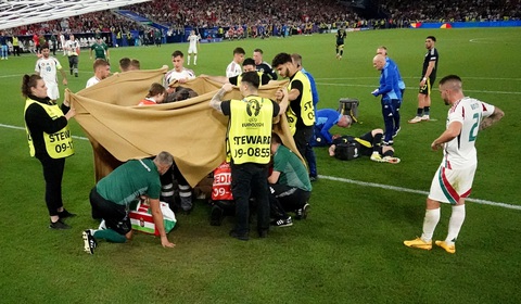 Tiền đạo Hungary bất tỉnh sau cú va chạm tại Euro 2024, đội trưởng Szoboszlai rơi nước mắt- Ảnh 2. Đội ngũ y tế dùng tấm bạt lớn để che chắn và sơ cứu cho Barnabas Varga - Ảnh: REUTERS