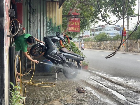 Tiệm rửa xe bắn nước tung tóe vào người đi đường, thải chất bẩn xuống cống- Ảnh 2. Tiệm rửa xe chỉ cách mặt đường chưa đầy 1m, ai đi ngang cũng