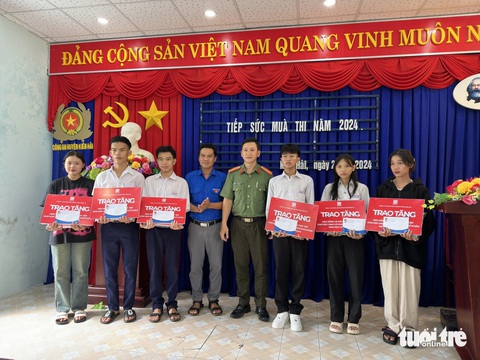 138 thí sinh huyện đảo Kiên Giang vượt biển vào đất liền thi tốt nghiệp THPT- Ảnh 4. Thiếu tá Trương Văn Quốc - trưởng Ban thanh niên Công an tỉnh Kiên Giang - trao học bổng tiếp sức cho các em thí sinh có hoàn cảnh khó khăn ở xã Hòn Tre (huyện Kiên Hải) đi thi - Ảnh: CHÍ CÔNG