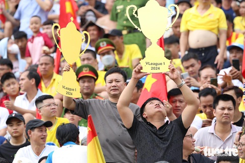 Khán giả trèo rào, đốt pháo sáng trên sân Thiên Trường mừng CLB Nam Định vô địch- Ảnh 4. CĐV Nam Định cầm cúp giả ăn mừng trên sân - Ảnh: HOÀNG TÙNG