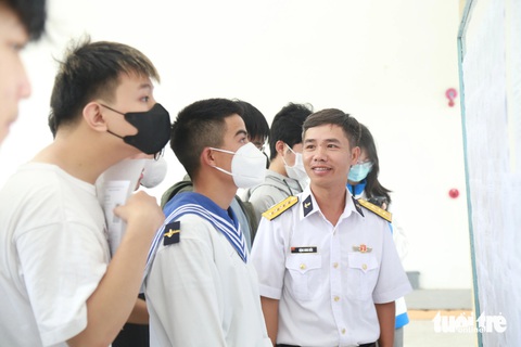 Đưa đồng đội đi thi tốt nghiệp mà... mất ngủ- Ảnh 1. Anh Đặng Song Hiếu (bìa phải) - Lữ đoàn 161 Vùng 3 Hải quân (Đà Nẵng) - có mặt tại điểm thi Trường THPT Phan Châu Trinh từ rất sớm để đưa đồng đội của mình đi nghe quy chế thi - Ảnh: ĐOÀN NHẠN