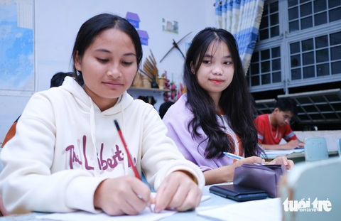 Thí sinh ôn tập nước rút trong đêm trước ngày thi- Ảnh 5. Nech và Thoay - hai thí sinh người Ba Na giúp nhau củng cố kiến thức trong buổi ôn thi tối 26-6 - Ảnh: TẤN LỰC