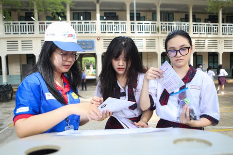 Hơn 1 triệu thí sinh làm thủ tục thi tốt nghiệp THPT- Ảnh 8. Tình nguyện viên hướng dẫn sơ đồ phòng thi cho thí sinh - Ảnh: PHƯƠNG QUYÊN