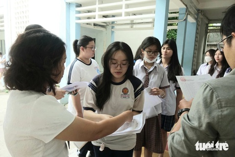 Hơn 1 triệu thí sinh cả nước thi tốt nghiệp THPT môn đầu tiên- Ảnh 4. Cán bộ coi thi đang gọi tên thí sinh vào phòng thi tại điểm thi trường THPT Hoàng Hoa Thám, quận Bình Thạnh, TP.HCM - Ảnh: NHƯ HÙNG