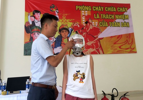 Những cách tự cứu mình khi gặp hỏa hoạn- Ảnh 1. Người dân tại một chung cư ở TP.HCM được hướng dẫn cách mang mặt nạ chống khói- Ảnh: T.T.D.