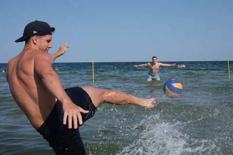 Mặc kệ chiến tranh, người dân Ukraine hòa vào không khí Euro 2024- Ảnh 4. Hai thanh niên người Ukraine hào hứng chơi bóng đá tại Biển Đen trước cơ hội của Ukraine tại mùa giải Euro 2024. Những bãi biển tại khu vực Odessa thường nhộn nhịp vào mỗi dịp cuối tuần, sau khi chính quyền xác nhận các mối đe dọa từ mìn đã giảm đáng kể - Ảnh: RICHARD MORGAN