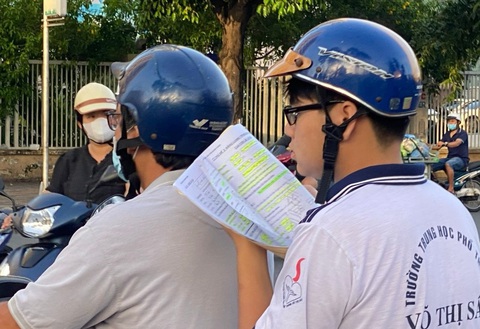 Những cái ôm của mùa thi tốt nghiệp- Ảnh 11. Tranh thủ ôn bài trên đường trước giờ vào phòng thi - Ảnh: TRẦN THỊ THU THẢO