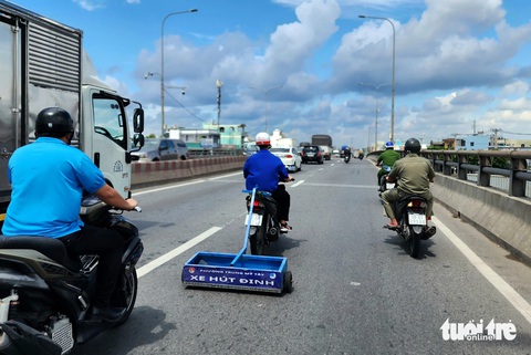 Ra quân hút đinh trên quốc lộ 1, đoạn qua cầu vượt An Sương- Ảnh 2. Đoàn thanh niên phường Trung Mỹ Tây (quận 12) phối hợp công an phường triển khai hút đinh trên cầu vượt An Sương vào trưa 29-6
