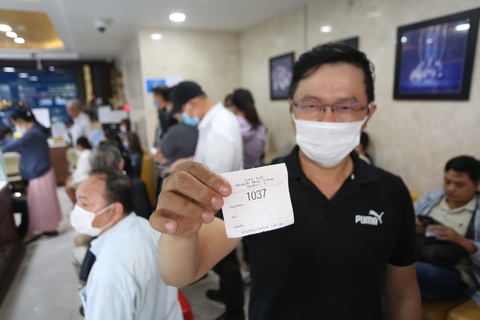 Ngày đầu ngân hàng bán vàng cho dân: Nhiều nơi 'cháy hàng', mới bán 1 tiếng đã hết- Ảnh 2. Khách hàng được phát số thứ tự để chờ tới lượt - Ảnh: PHƯƠNG QUYÊN