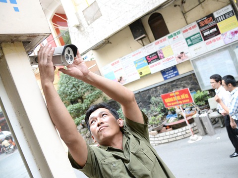 Lo phiền khi camera Lực lượng dân phòng kiểm tra, điều chỉnh góc máy camera giám sát không gian công cộng tại một con hẻm trên địa bàn quận 1, TP.HCM - Ảnh: TỰ TRUNG