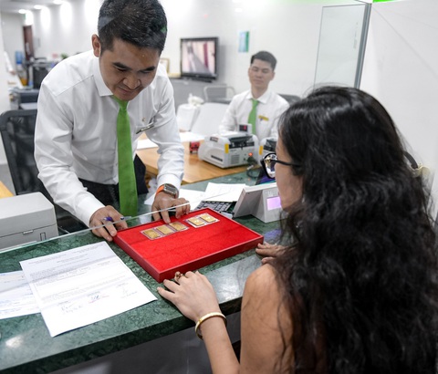 Dự báo giá bán vàng miếng SJC tiếp tục giảm, người dân cân nhắc mua vào- Ảnh 1. Khách hàng mua được vàng từ Vietcombank trong buổi giao dịch ngày 3-6 - Ảnh: NAM TRẦN