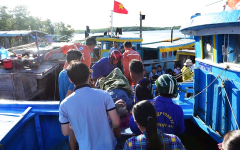 Hiểm nguy cấp cứu trên biển- Ảnh 2. Bệnh nhân ở xã đảo Thạnh An, huyện Cần Giờ (TP.HCM) được chuyển vào đất liền bằng ghe gỗ - Ảnh: DUYÊN PHAN