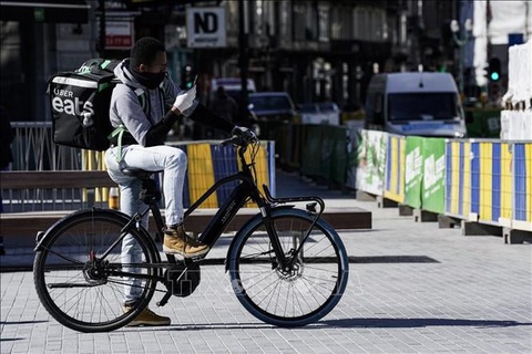Nhân viên giao hàng di chuyển bằng xe đạp trên đường phố tại Brussels, Bỉ. Ảnh: AFP/TTXVN Nhân viên giao hàng di chuyển bằng xe đạp trên đường phố tại Brussels, Bỉ - Ảnh: AFP/TTXVN