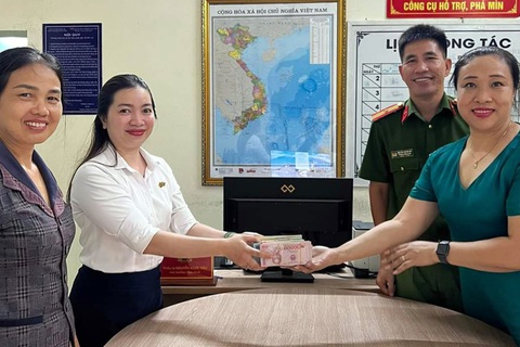 Tài khoản bỗng nhận 240 triệu đồng, người phụ nữ ở Đồng Nai nhờ công an xác minh- Ảnh 1. Chị Phương (áo trắng) trao trả toàn bộ số tiền chuyển nhầm tài khoản cho chị Nhị tại trụ sở Công an xã Quảng Tiến - Ảnh: NGUYÊN HƯNG