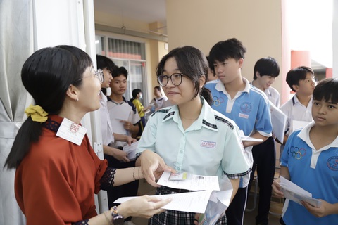 Sáng nay 6-6, hơn 98.600 học sinh TP.HCM thi vào lớp 10- Ảnh 5. Cán bộ coi thi kiểm tra giấy báo dự thi và giấy tờ cá nhân thí sinh trước khi vào phòng thi môn văn tại điểm thi trường THCS Kim Đồng Q.5, TP.HCM - Ảnh: NHƯ HÙNG