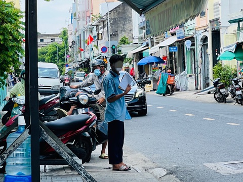Phát tờ rơi bát nháo trước cổng trường thi vào lớp 10- Ảnh 3. Một học sinh dùng tờ rơi quạt cho mát sau khi kết thúc phần thi buổi sáng