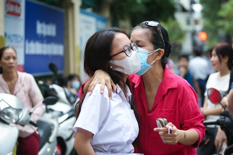 Nữ sinh người Việt gốc Hàn Sim Bo Mim được mẹ thơm má trước khi vào phòng thi môn toán ở điểm thi THPT Trưng Vương (quận 1). Một phụ huynh hôn động viên con trước kỳ thi vào lớp 10 vừa qua ở TP.HCM - Ảnh: PHƯƠNG QUYÊN