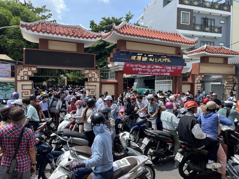 Phát tờ rơi bát nháo trước cổng trường thi vào lớp 10- Ảnh 4. Những tờ rơi được nhét tận yên xe (xe ngoài cùng) một phụ huynh đưa đón con đi thi