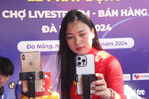 TikToker hướng dẫn tiểu thương chợ Cồn livestream bán hàng- Ảnh 1. Hướng dẫn livestream bán hàng trước chợ Cồn, Đà Nẵng - Ảnh: TRƯỜNG TRUNG