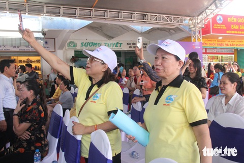 TikToker hướng dẫn tiểu thương chợ Cồn livestream bán hàng- Ảnh 2. Tiểu thương chợ Cồn hào hứng khi được nghe hướng dẫn thương mại điện tử - Ảnh: TRƯỜNG TRUNG
