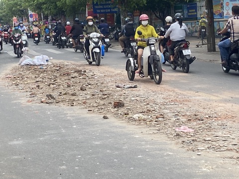 Xà bần đổ đầy đường, dân phải dùng bao cát cảnh báo xe cộ- Ảnh 1. Đống xà bần kéo dài hàng chục mét trên đường Hương Lộc 2 gây khó khăn cho xe cộ qua lại sáng 7-6 - Ảnh: HỒNG ĐIỆP