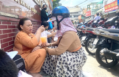 Phụ huynh khác tiếp sức cho mẹ con bà Trang bằng những ly nước cam nghĩa tình - Ảnh: NGỌC PHƯỢNG Phụ huynh khác tiếp sức cho mẹ con bà Trang bằng những ly nước cam nghĩa tình - Ảnh: NGỌC PHƯỢNG