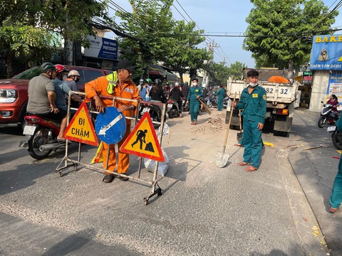 Xà bần đổ đầy đường, dân phải dùng bao cát cảnh báo xe cộ- Ảnh 3. Ban chỉ huy quân sự phường Bình Trị Đông huy động lực lượng xuống địa điểm tiến hành điều tiết giao thông và khắc phục sự cố - Ảnh: CTV
