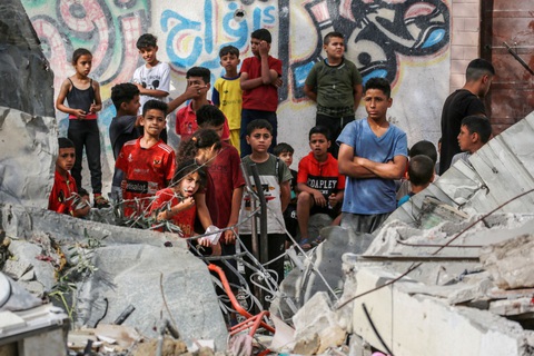 Những đứa trẻ Palestine đứng sau một ngôi nhà bị đánh sập ở Nuseirat, miền trung Gaza - Ảnh: AFP Những đứa trẻ Palestine đứng sau một ngôi nhà bị đánh sập ở Nuseirat, miền trung Gaza, ngày 30-5 - Ảnh: AFP