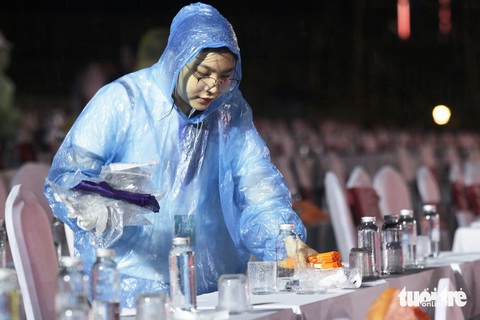 Bạn trẻ đội mưa lau sân khấu, phục vụ lễ khai mạc Festival Huế 2024- Ảnh 1. Dưới cơn mưa tầm tã, các bạn tình nguyện viên tích cực làm nhiệm vụ phục vụ cho đêm khai mạc Tuần lễ Festival Huế 2024 - Ảnh: BẢO PHÚ