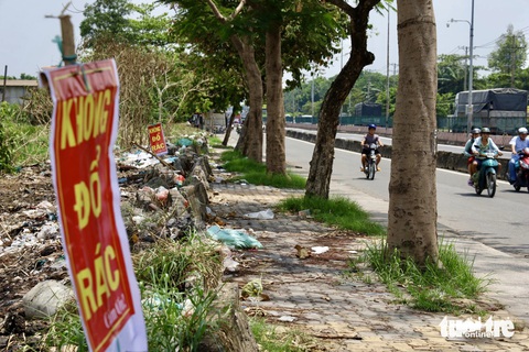 Xử lý, dọn dẹp các điểm đen xả rác thải sau phản ánh của Tuổi Trẻ- Ảnh 2. Dọc tuyến đường quốc lộ 1 đã được dọn dẹp phần nào rác thải chất đống, cắm biển cấm đổ rác - Ảnh: NGỌC QUÝ