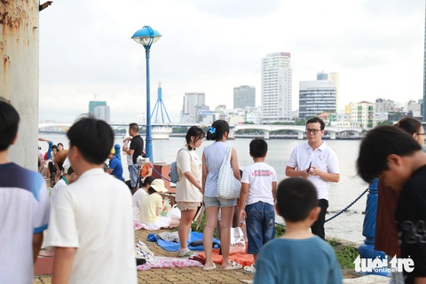 Bờ sông Hàn nhộn nhịp, người dân tới sớm 5 tiếng 'xí' chỗ xem pháo hoa quốc tế- Ảnh 1. Trước thời điểm diễn ra phần trình diễn pháo hoa 5 tiếng, những vị trí đắc địa ven sông Hàn đã kín chỗ - Ảnh: ĐOÀN NHẠN