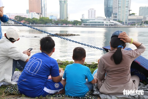 Bờ sông Hàn nhộn nhịp, người dân tới sớm 5 tiếng 'xí' chỗ xem pháo hoa quốc tế- Ảnh 8. Một gia đình tranh thủ lót dạ đợi giờ khai pháo - Ảnh: ĐOÀN NHẠN