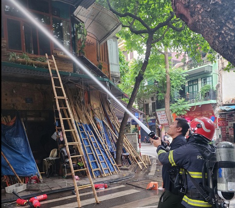 Quán cà phê ở phố cổ Hà Nội bốc cháy ngùn ngụt- Ảnh 2. Cảnh sát tiến hành dập lửa - Ảnh: Công an cung cấp