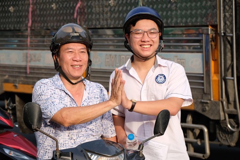 Sáng nay 106.000 thí sinh Hà Nội thi vào lớp 10 môn văn- Ảnh 2. Phụ huynh động viên con em trước khi vào làm bài thi môn đầu tiên của kỳ thi tuyển sinh vào lớp 10 tại Hà Nội - Ảnh: NGUYÊN BẢO