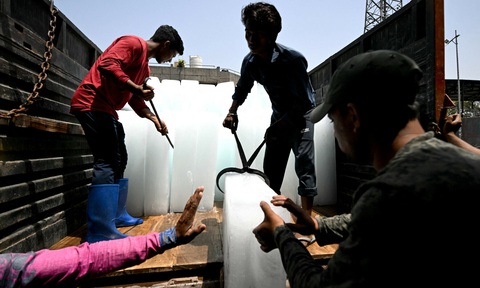 Workers stack ice blocks at a market during a hot summer day in New Delhi on May 30, 2024, amid ongoing heatwave. — AFP Công nhân khuân nước đá tại một khu chợ ở New Delhi, Ấn Độ hôm 30-5, trong bối cảnh nắng nóng đang diễn ra - Ảnh: AFP
