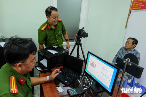 Làm thẻ căn cước mới ở TP.HCM chỉ mất 5-10 phút- Ảnh 4. Các cán bộ chụp ảnh cho bà Đặng Thị Châu (78 tuổi, ngụ huyện Bình Chánh) để làm hồ sơ cấp thẻ căn cước