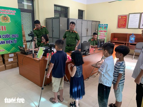 Công an Hà Nội bắt đầu cấp thẻ căn cước cho trẻ em- Ảnh 2. Nhiều trẻ em ở Hà Nội được phụ huynh đưa đến trụ sở công an để làm thẻ căn cước từ sớm - Ảnh: ANH TẤN